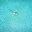 Woman on a stand up paddle boat over turquoise waters